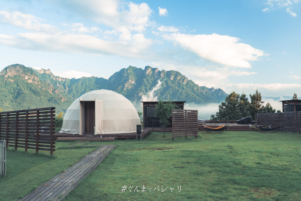 晴れた朝のドームテントと妙義山。山肌に雲が残る