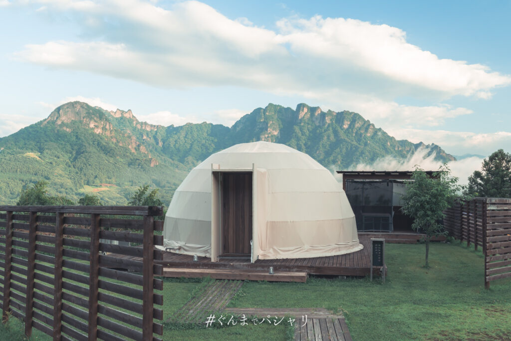 ドームテントの背後にそびえる妙義山の岩峰